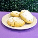 Yellow colored lemon sugar cookies on a white plate